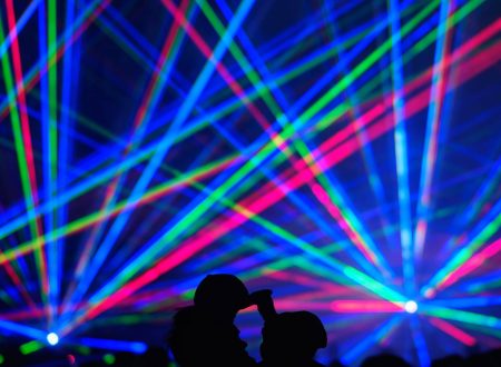 Proyección de rayos láser multicolores sobre el público en un espectáculo visual.