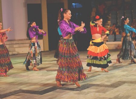 Grupo de bailarinas con faldas coloridas ejecutando danza folklórica.
