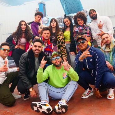 : Víctor Óscar Juaranz posa junto a Kiko Rivera y otros artistas en una actitud desenfadada durante el rodaje de un videoclip con estética urbana y ambiente canalla.